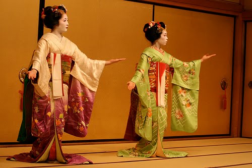 Two Maiko wearing Hikizuri, you can see the tucks in the sleeves and in the shoulders. You can also see how they drag on the ground as the girls dance.